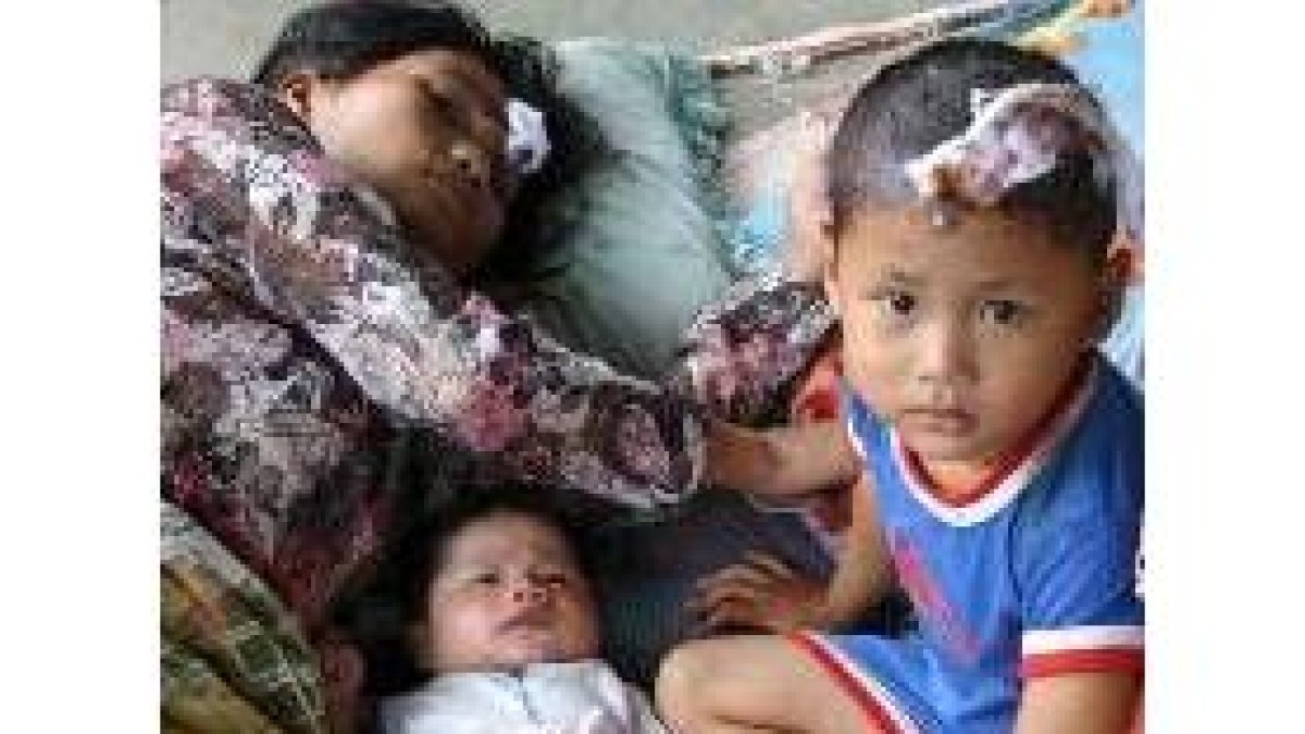 Una madre con sus dos hijos, en un hospital de campaña en Nias