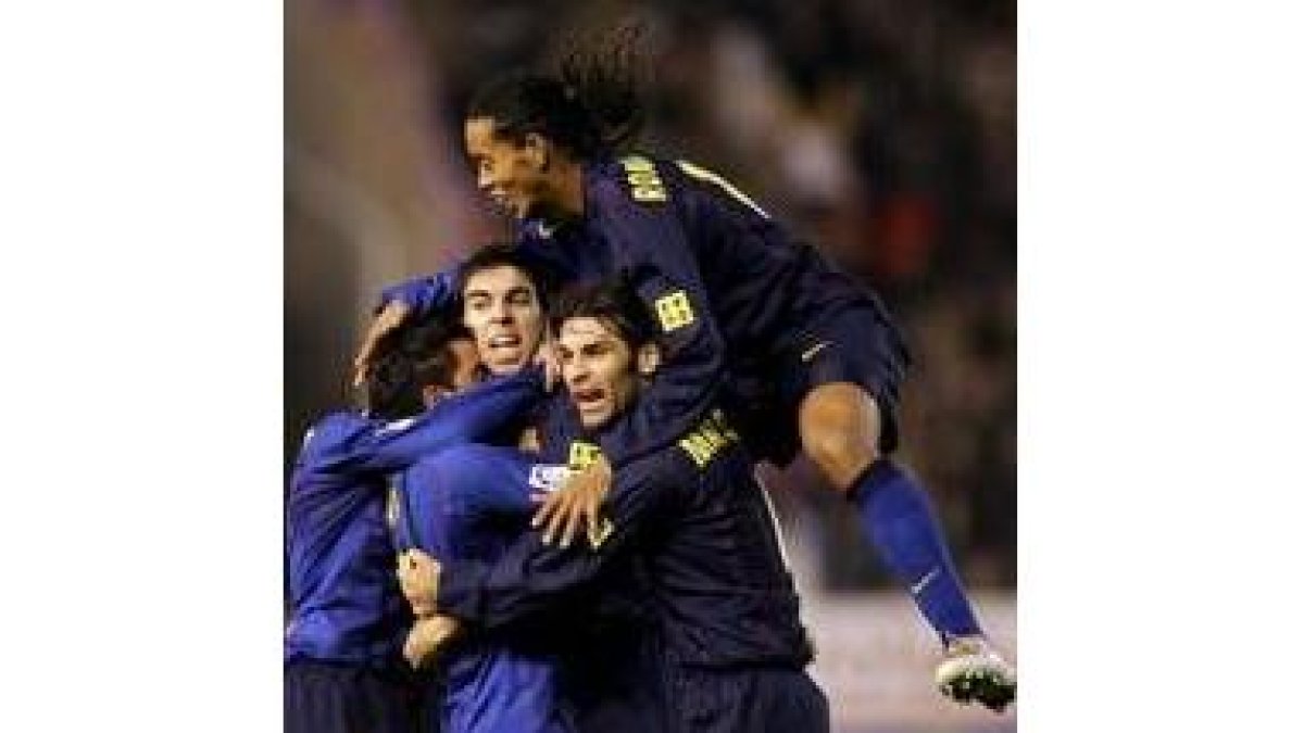 Ronaldinho salta sobre la piña de jugadores que celebran uno de los goles del Barcelona