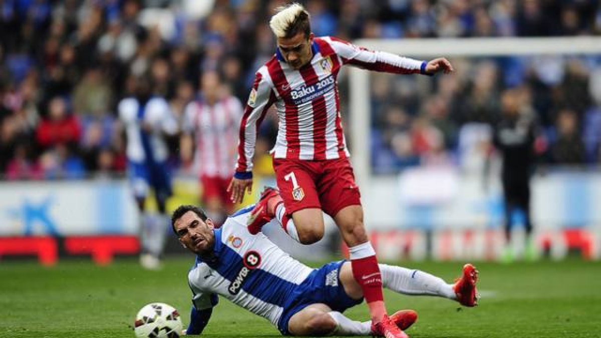 Abraham y Griezmann peleam por el balón, en un momento del partido que ha enfrentado al Espanyol y el Atlético en Cornellà.