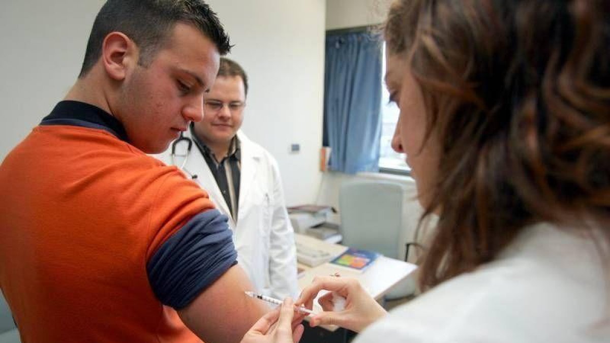 Una enfermera vacuna a un paciente contra la gripe.