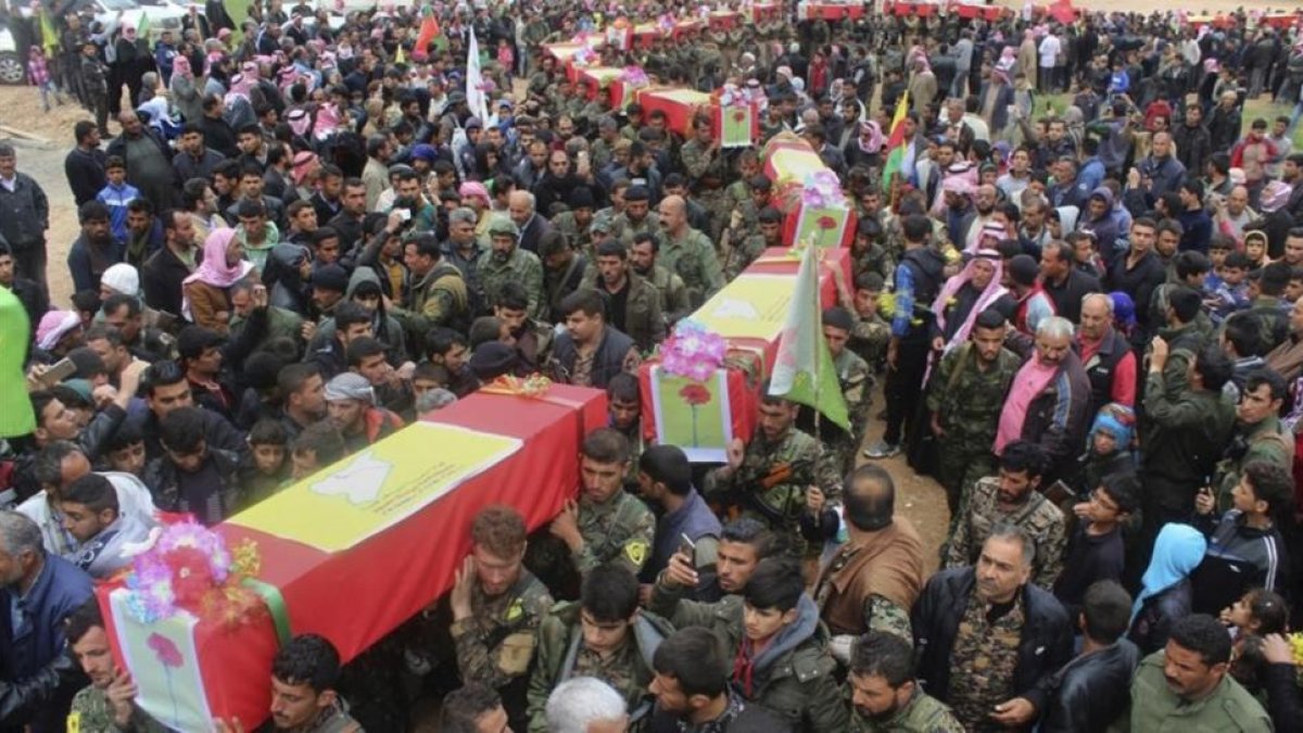 Miliciamos de las Fuerzas Democráticas de Siria llevan los féretros de sus compañeros muertos en el ataque perpetrado por error por aviones de EEUU.