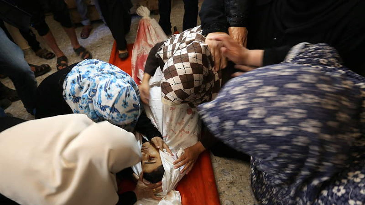 Varios palestinos lloran el cuerpo de una víctima.