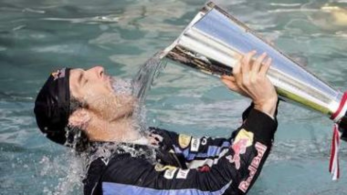 Mark Webber se baña en una piscina con el trofeo.