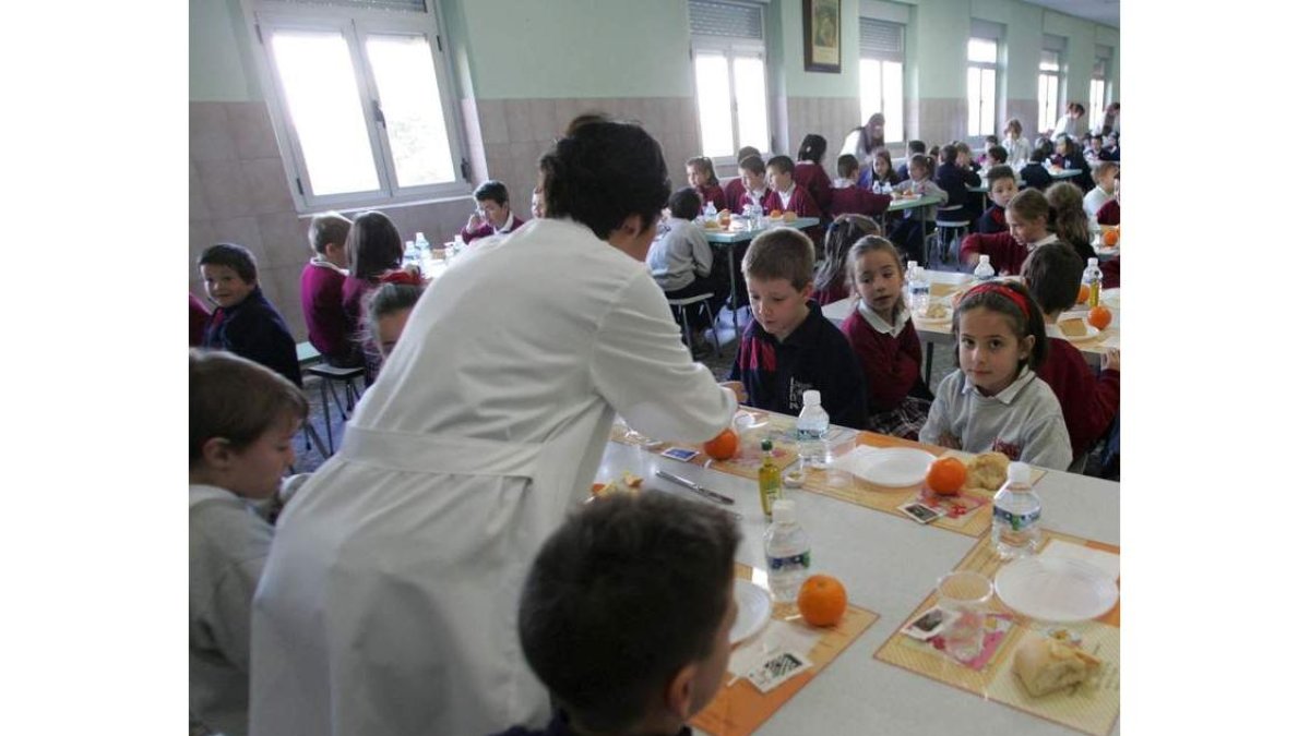 Ninos y niñas comen en un colegio de León.
