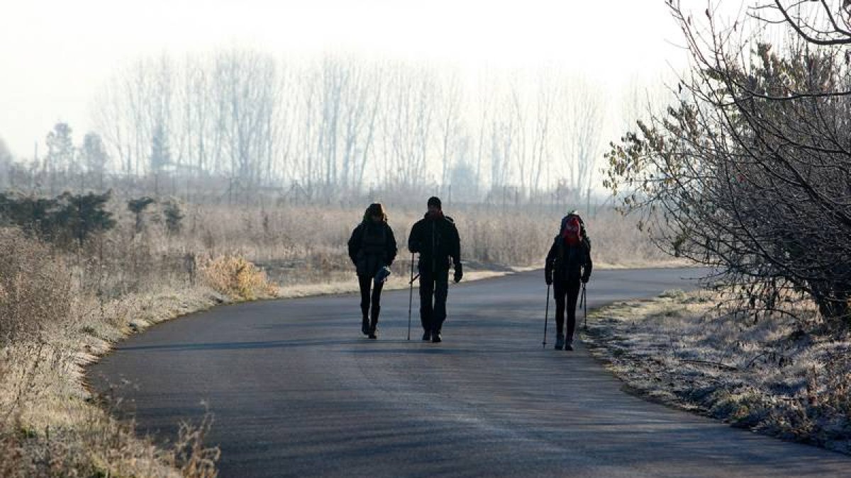 Tres peregrinos caminan a primera hora de la mañana en Fuentesnuevas.