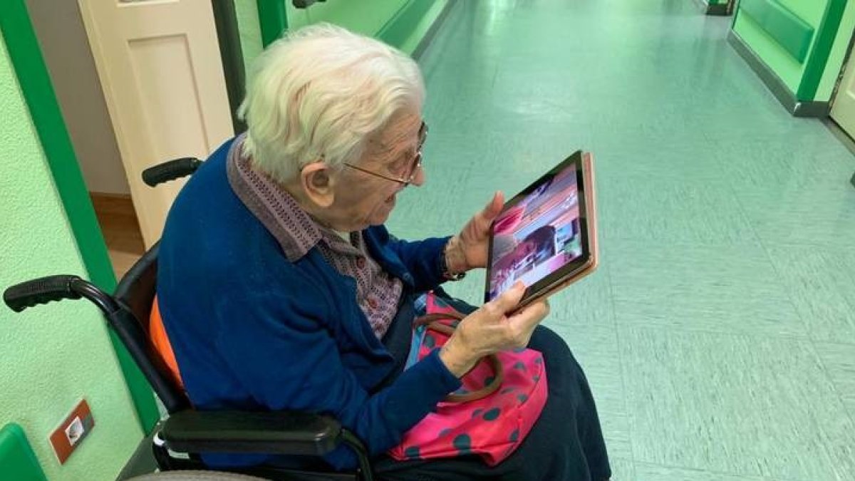 Una mayor se comunica por tablet con su familia. DL