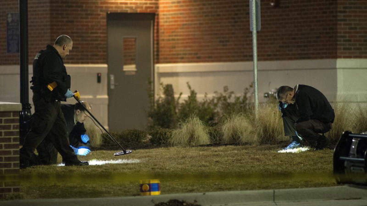 Los investigadores buscan evidencias a las puertas del Departamento de policía de Ferguson.