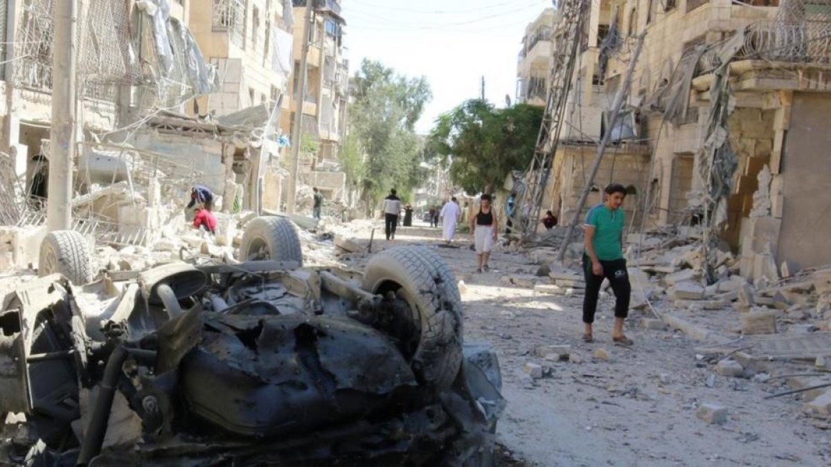 Varias personas inspeccionan los daños causados por un bombardeo nocturno contra el barrio rebelde de Seif al-Dawla, en Alepo, el 30 de septiembre.