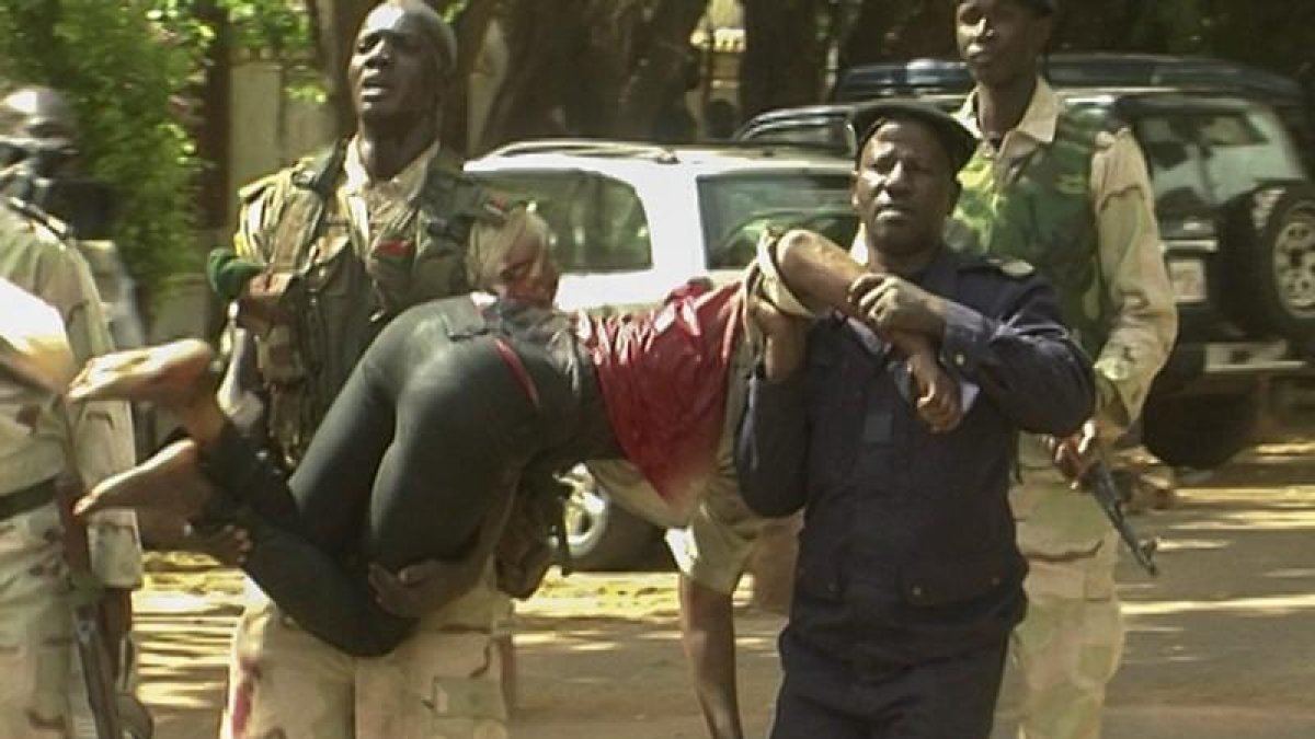 militar de Mali traslada a una mujer herida a su salida del hotel de lujo Radisson Blu en Bamako