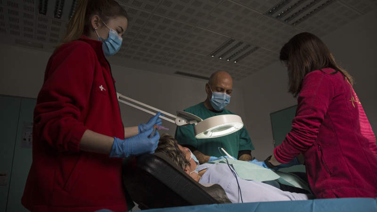 Las enfermeras Lucía Rodríguez y Nuria del Pozo participan junto al médico Domingo García en una cirugía menor en el ambulatorio de Trobajo. FERNANDO OTERO