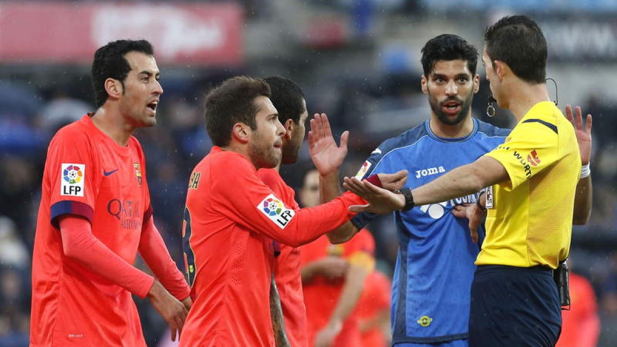 Futbolistas del Barça le protestan al árbitro una decisión suya durante el partido con el Getafe.