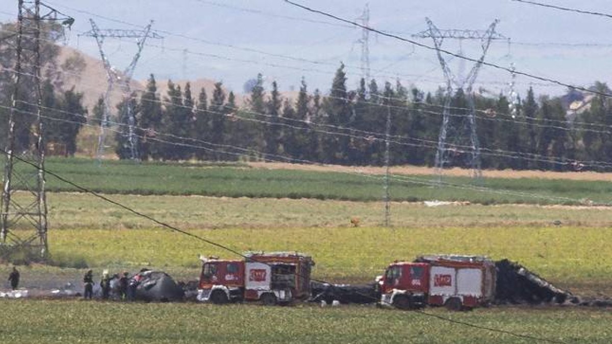 Los equipos de emergencia y bomberos junto al avion siniestrado, este sábado, en el aeropuerto de San Pablo de Sevilla.