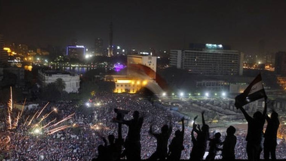 Egipcios enarbolan banderas ante el espectáculo de la plaza de Tahrir.