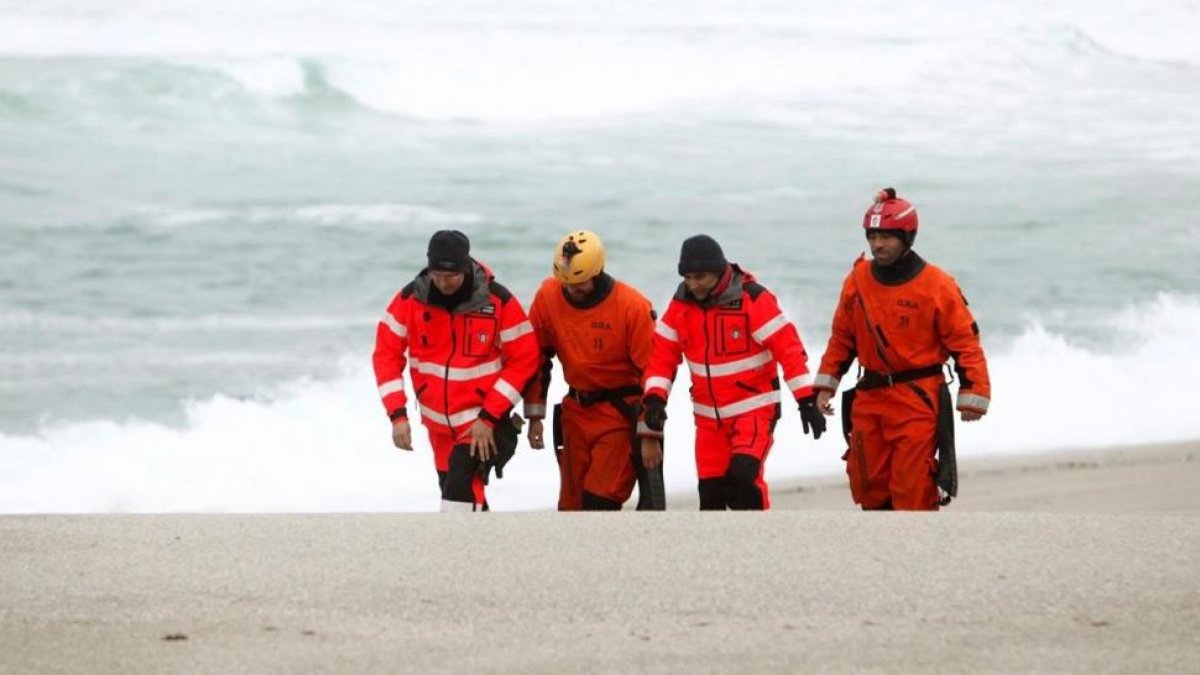 Miembros del equipo de emergencias que busca a la joven desaparecida el viernes en una playa de Orzán, en A Coruña.