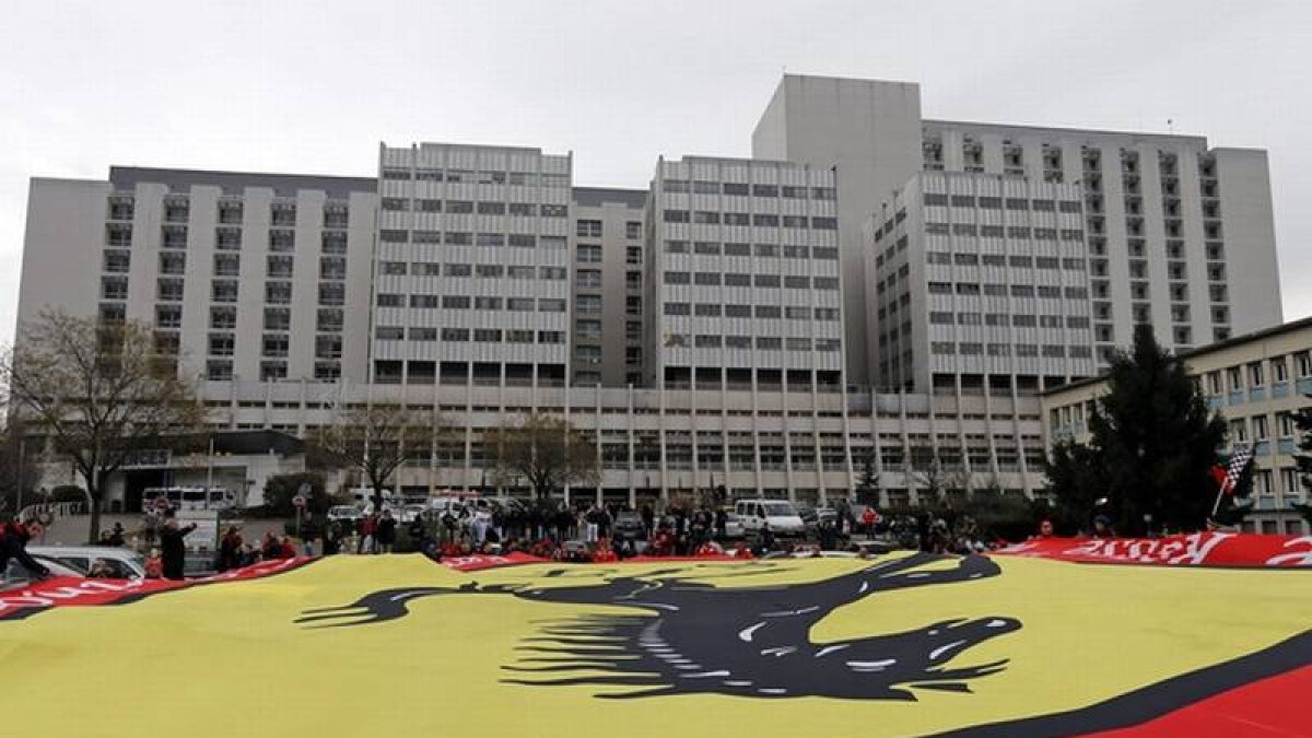 Seguidores de Schumacher despliegan una bandera gigante de Ferrari frente al hospital de Grenoble, este viernes.