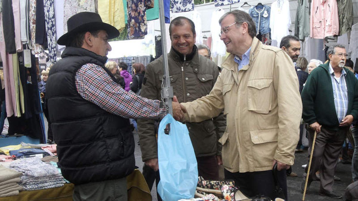 Antonio Silván saluda a uno de los vendedores del Rastro, ayer durante su recorrido