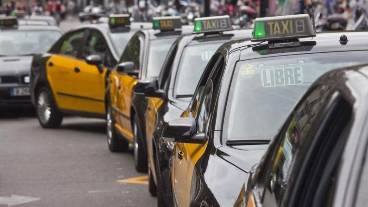Taxis esperan en Plaza Cataluña.