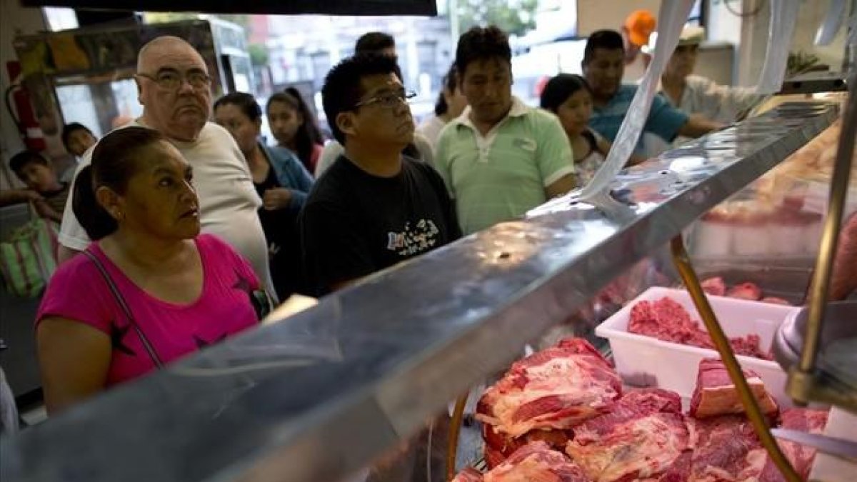 Unos clientes compran carne de vacuno en un mercado de Buenos Aires.
