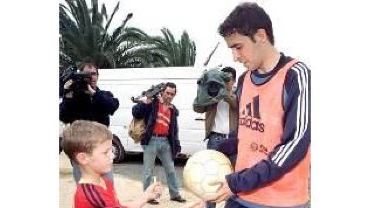 Raúl, que regala un balón a un niño, sigue siendo la principal atracción de la hinchada española