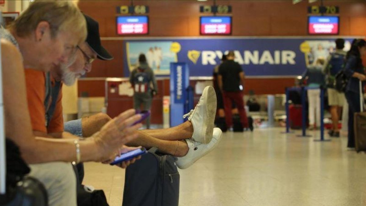 Viajeros esperan en el aeropuerto de Barcelona-El Prat.
