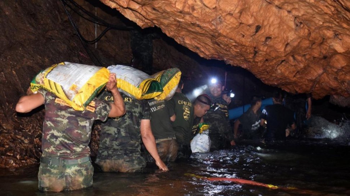 Varios miembros de un equipo de rescate intentan drenar el agua de la cueva Tham Luang en Khun Nam Nang Non Forest Park (Tailandia).
