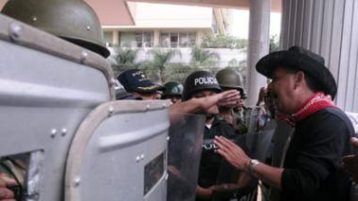 Un simpatizante del depuesto presidente hondureño discute con un grupo de policías.