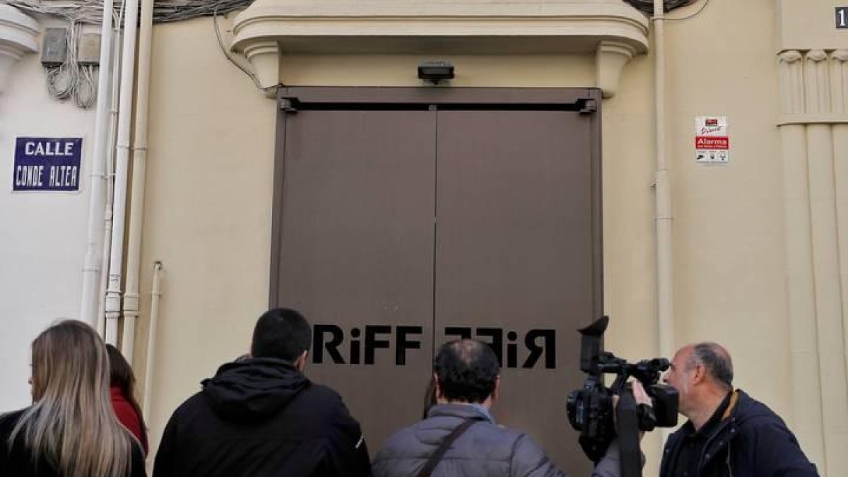 Varios cámaras de televisión y periodistas esperan a las puertas del restaurante RiFF de Valencia.