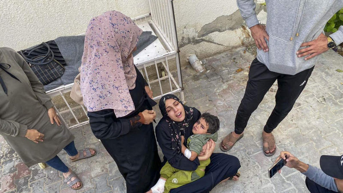 Imagen de una mujer con su hijo tras los bombardeos en Gaza que ayer se reanudaron. ANAS BABA