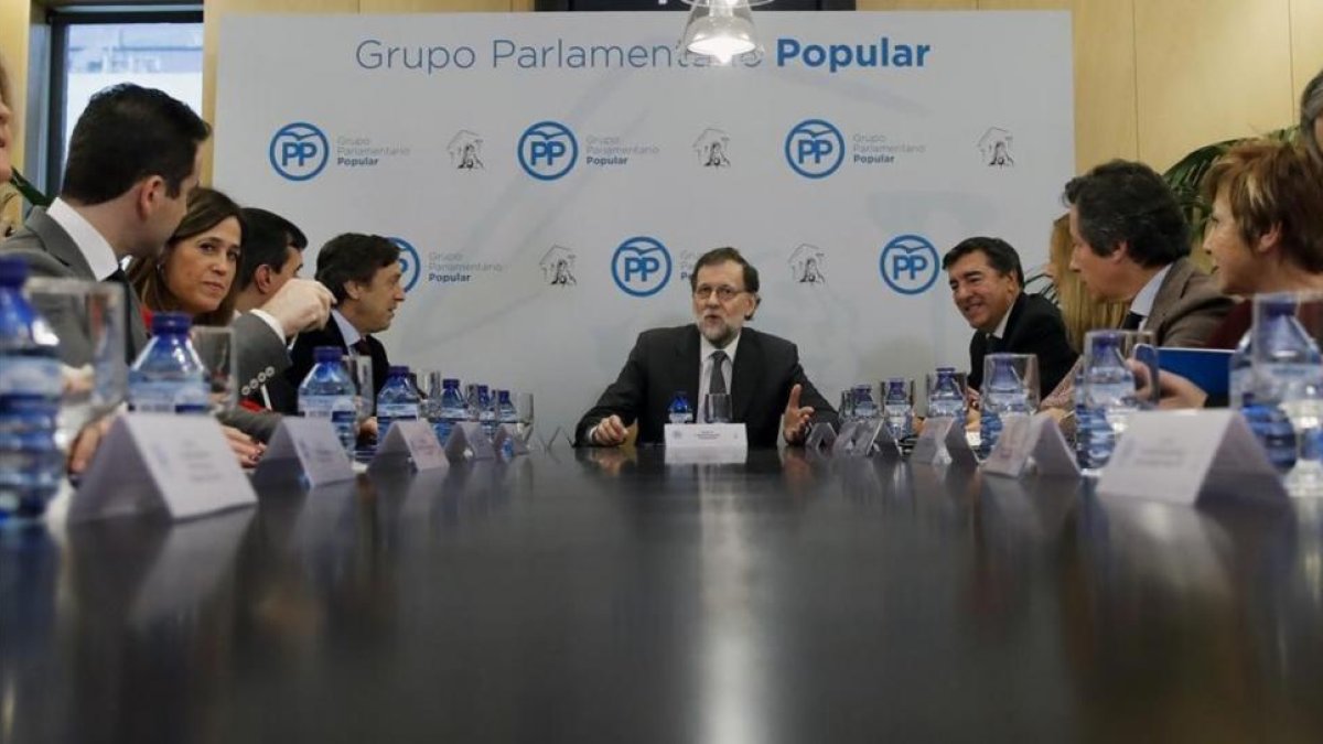 El líder del PP, Mariano Rajoy, en una reunión del grupo parlamentario popular a la que asiste (a su derecha) el secretario general, José Antonio Bermúdez de Castro.