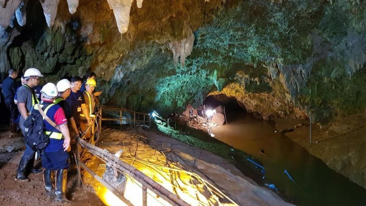 Varios miembros de los servicios de rescate tailandeses inspeccionan la cueva donde están atrapados los 12 niños del equipo de fútbol y su entrenador.