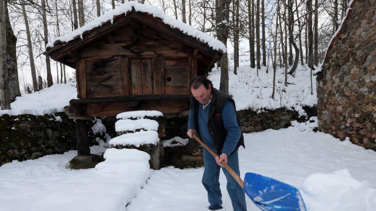 Un vecino de Lario espala nieve en una finca de su propiedad.
