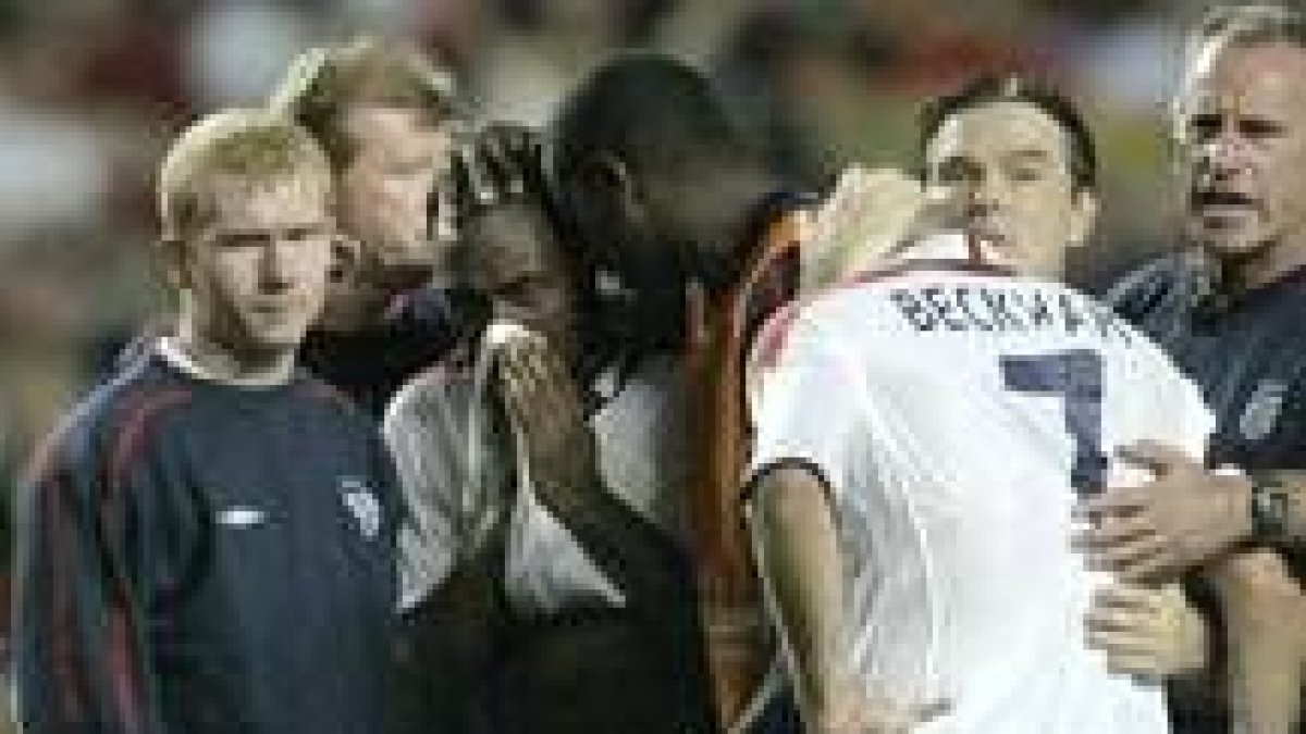 Los compañeros de la selección inglesa animan a Beckham después de que éste fallara el penalti