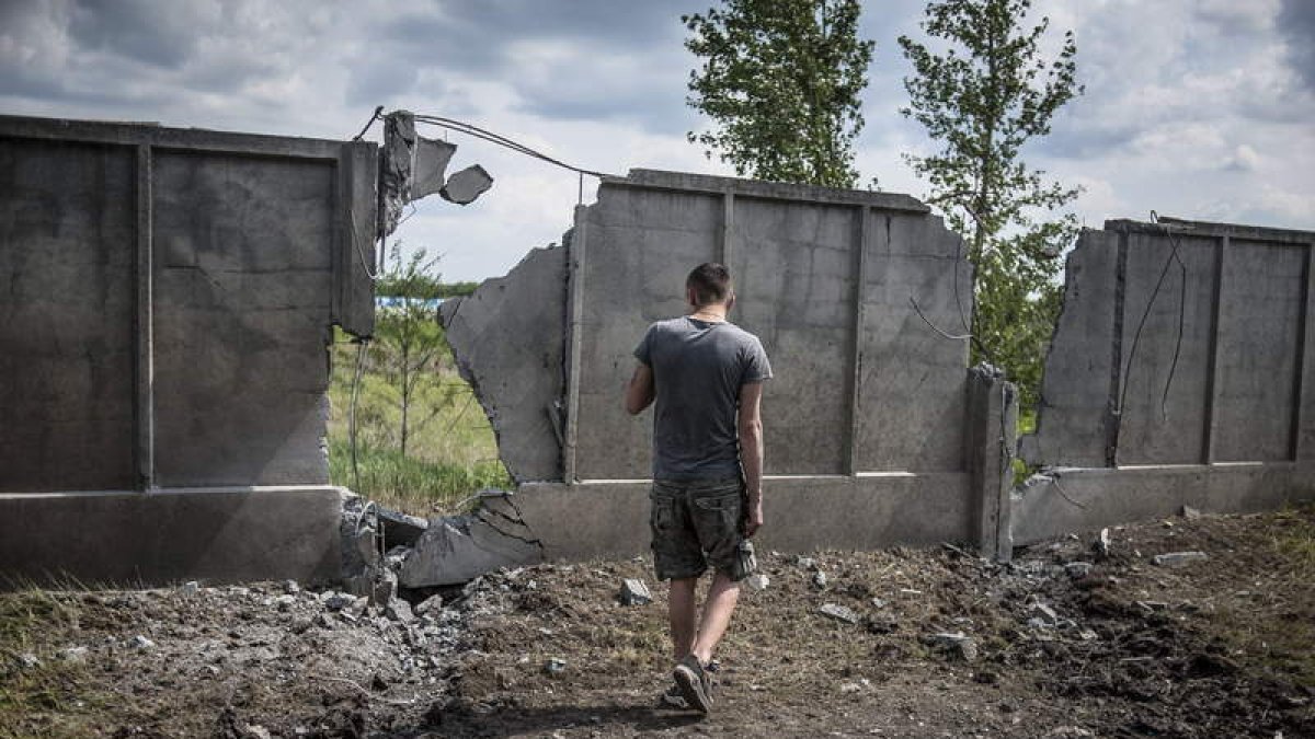 Un hombre observa un muro destrozado tras un ataque cerca de Sloviansk.