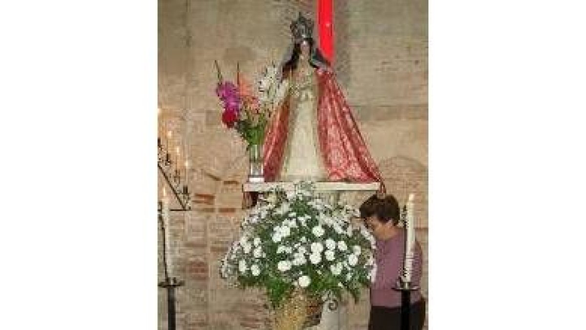 Julia Tovar alisa el vestido de la Virgen del Puente