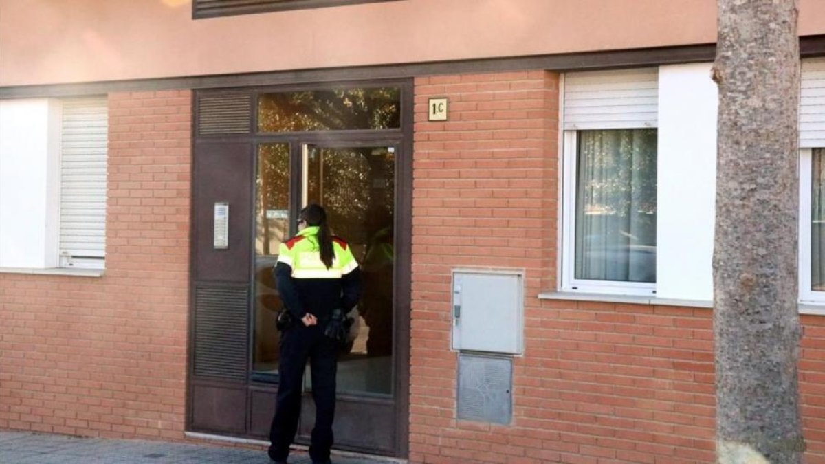 Una agente de los Mossos dEsquadra entra en la vivienda que la madre del bebé compartía con el detenido en Torroella de Montgrí, el domingo.