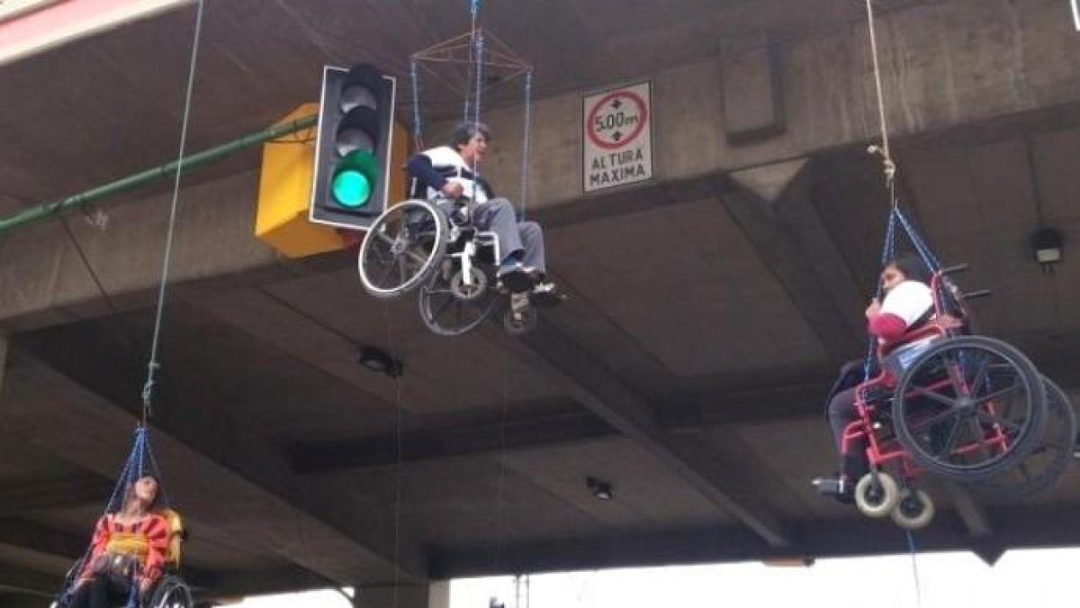 Personas con discapacidad se cuelgan de un puente en Bolivia.
