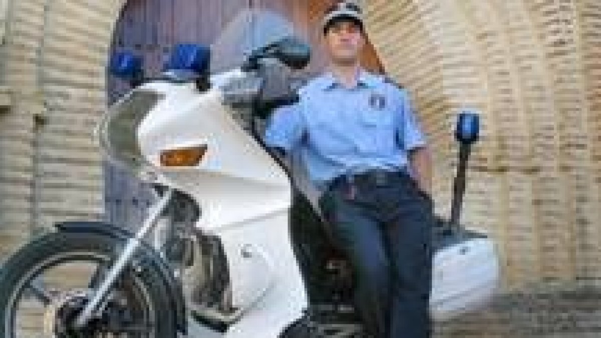 Sergio Cuevas, el primer municipal de Sahagún, posa junto a la moto con la que patrulla