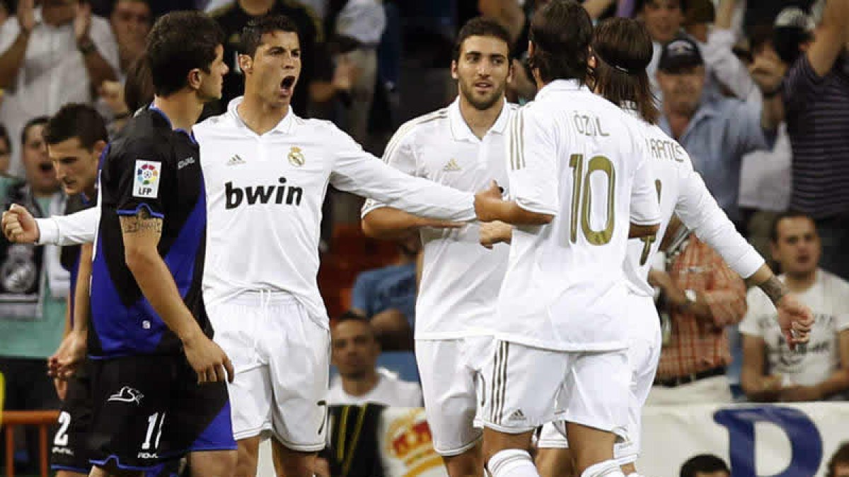 Cristiano Ronaldo celebra con sus compañeros Higuaín y Özil su tercer gol ante el Rayo.