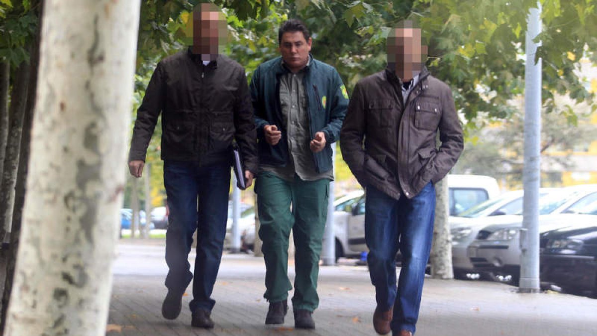 El celador de la Reserva de Caza, vestido con su uniforme y en medio de dos agentes de la Guardia Civil tras su detención.