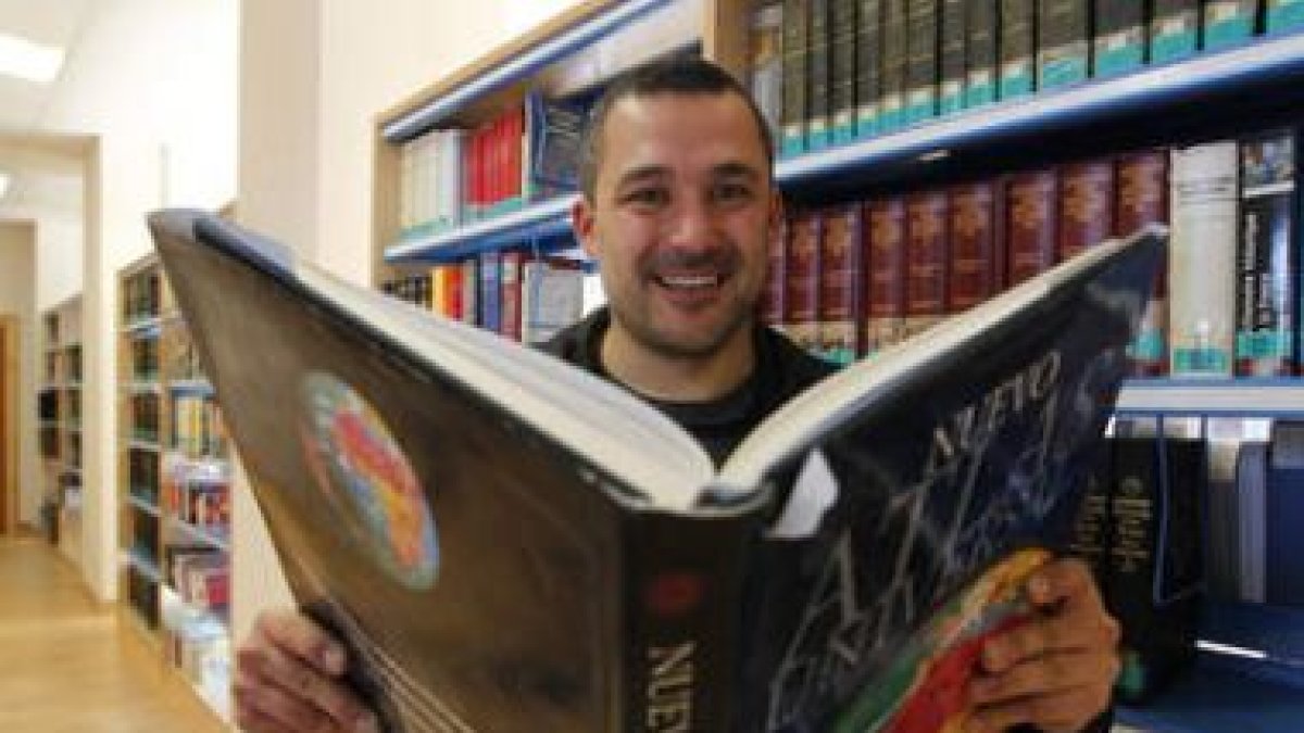 Diego Soto posa con un Atlas en la biblioteca de Filosofía y Letras, donde estudia Geografía.