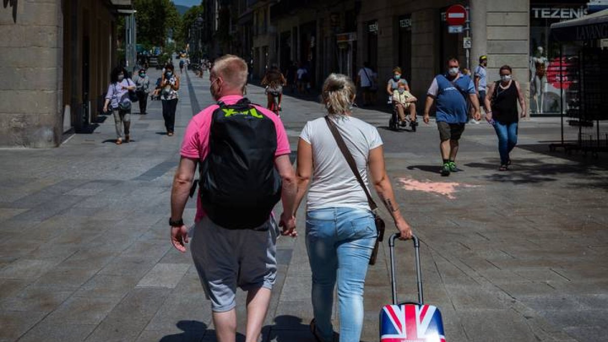 na pareja de turistas británicos caminan por el centro de Barcelona este lunes. ENRIC FONTCUBERTA
