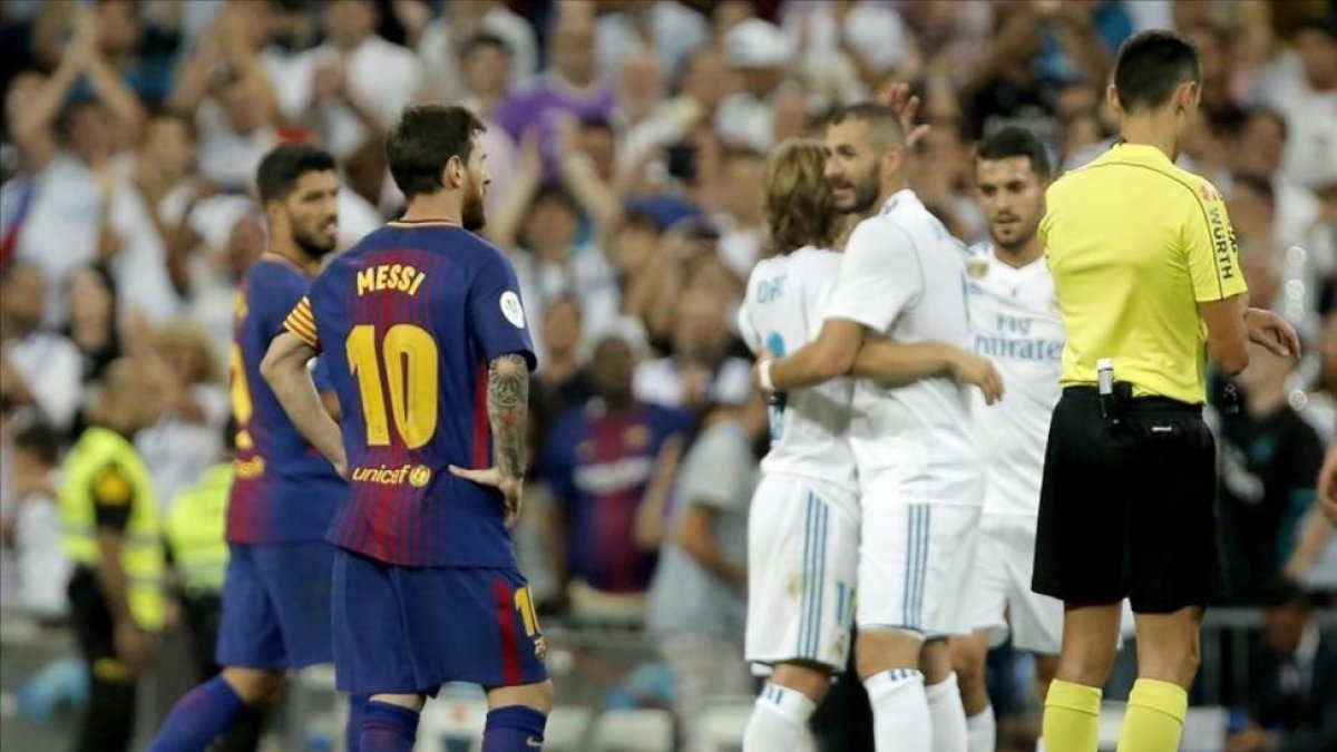 Benzema es felicitado por su gol, con Messi como testigo.