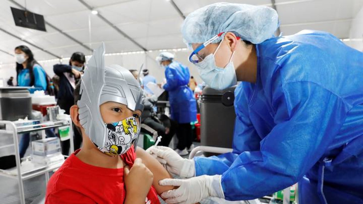 Un menor recibe la vacuna en Bogotá en plena celebración de Halloween. CARLOS ORTEGA