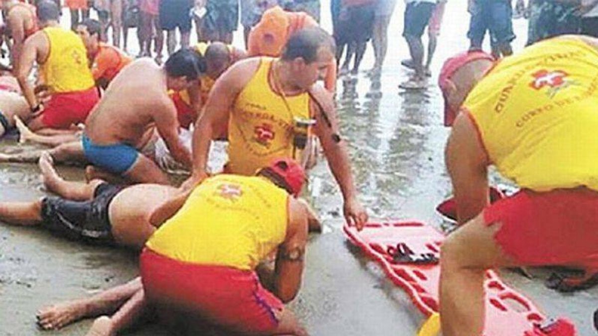 Socorristas reanimando a las víctimas tras la caída del rayo en Praia Grande (Brasil).