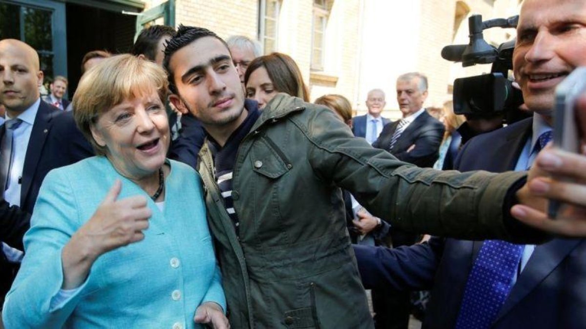 El refugiado sirio Anas M. se hace un selfie con Merkel, en septiembre del 2015.