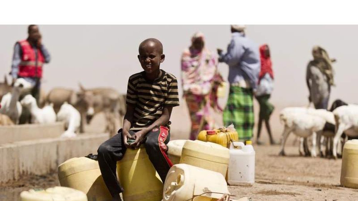 Un menor llena garrafas de agua en Kenia. JAKOB DALL / DANISH RED CROSS /
