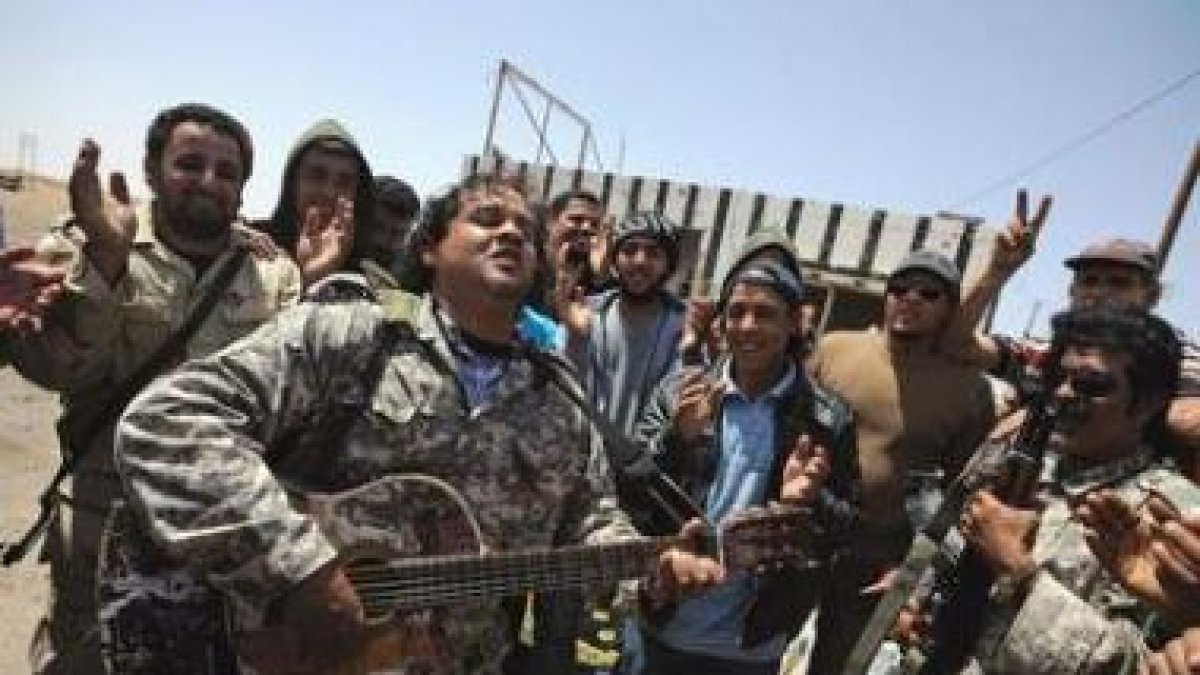 Miembros de las fuerzas rebeldes celebran la defensa de sus posiciones en Ajdabiya.