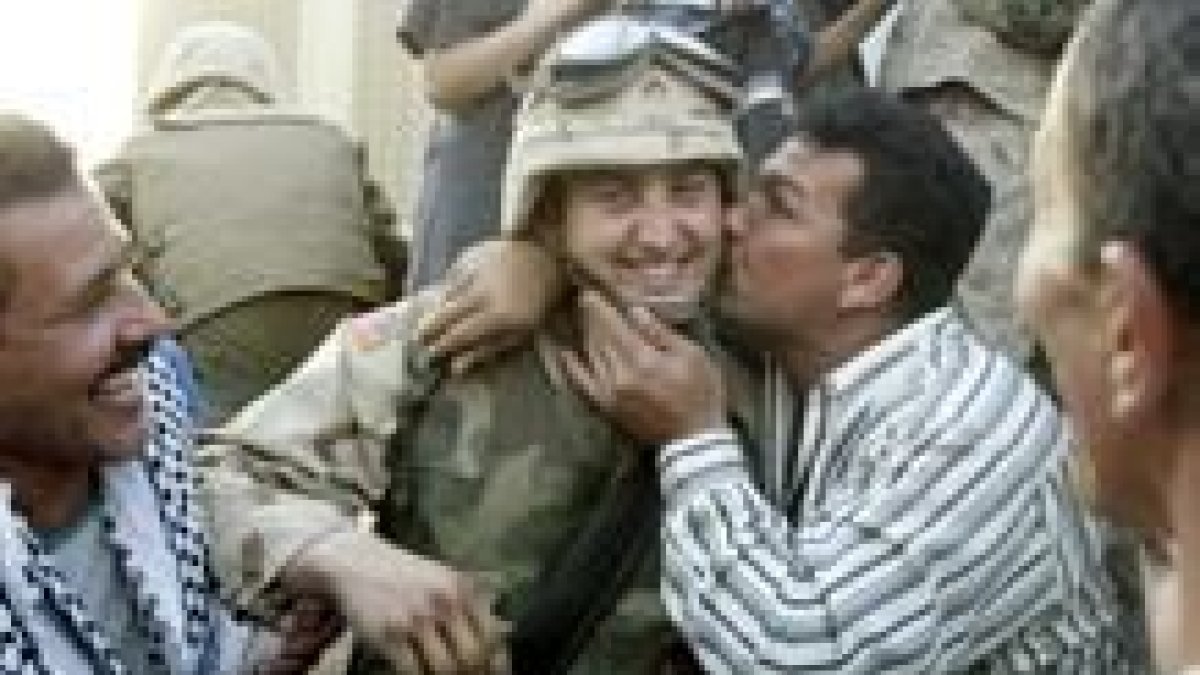 Un iraquí besa a un marine después de que los tanques norteamericanos llegaran al centro de Bagdad.