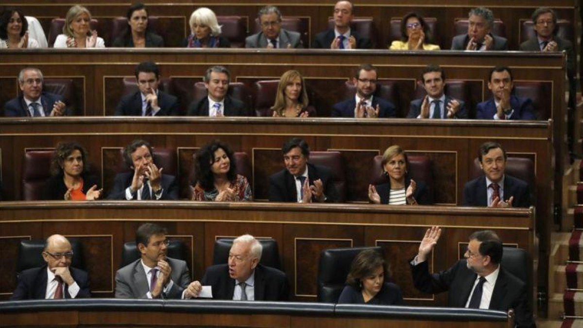 La bancada del PP aplaude a Mariano Rajoy tras su réplica al portavoz del PSOE, Antonio Hernando.