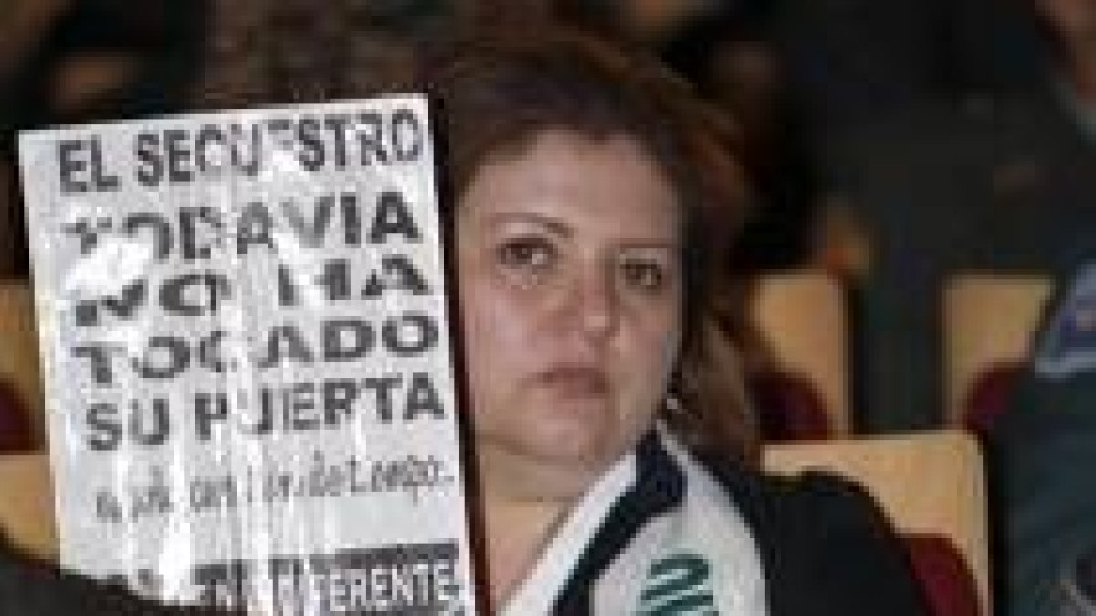 Una de las participantes en el Congreso muestra un cartel alertando de los secuestros